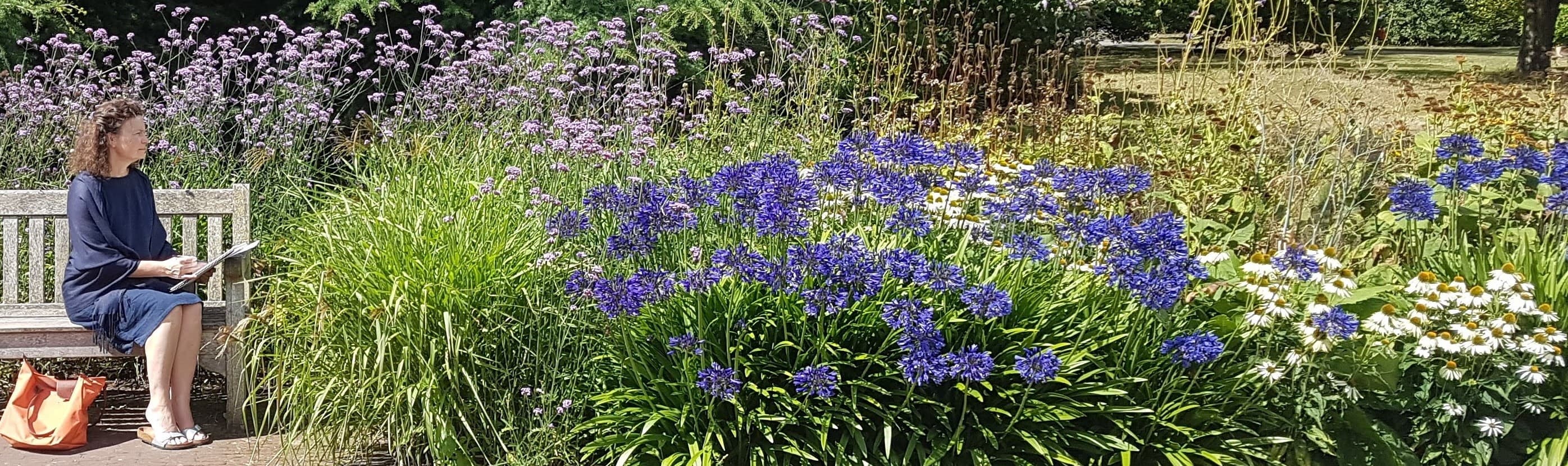 Judith Brown sketching on a garden bench