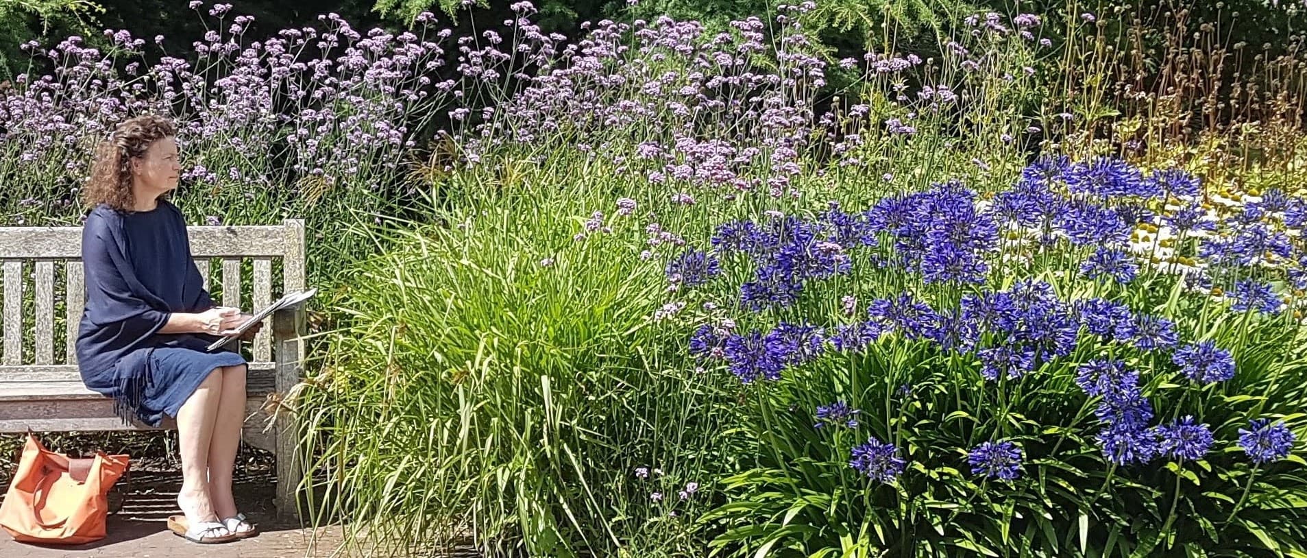 Judith Brown sketching on a garden bench