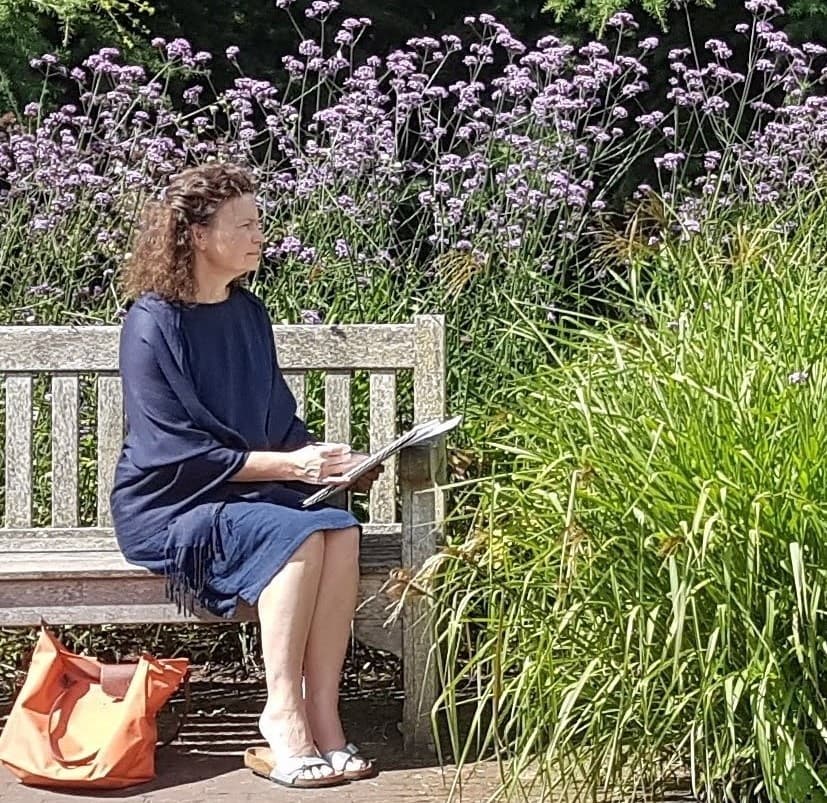 Judith Brown sketching on a garden bench